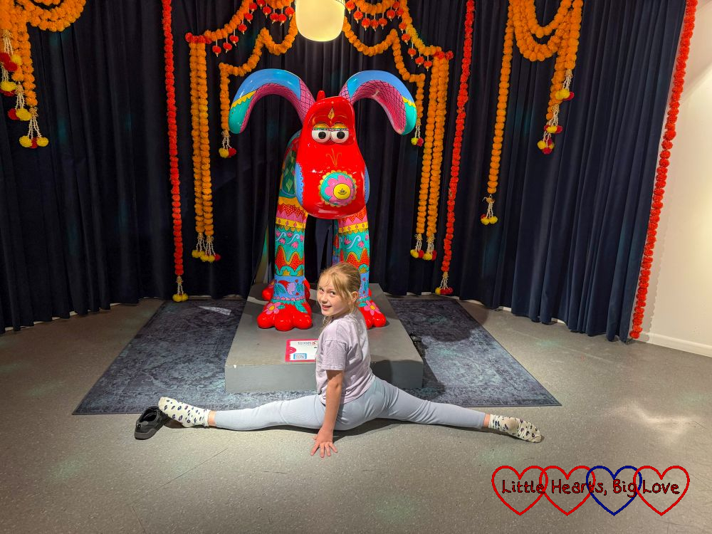 Sophie doing the splits in front of one of the Gromit sculptures