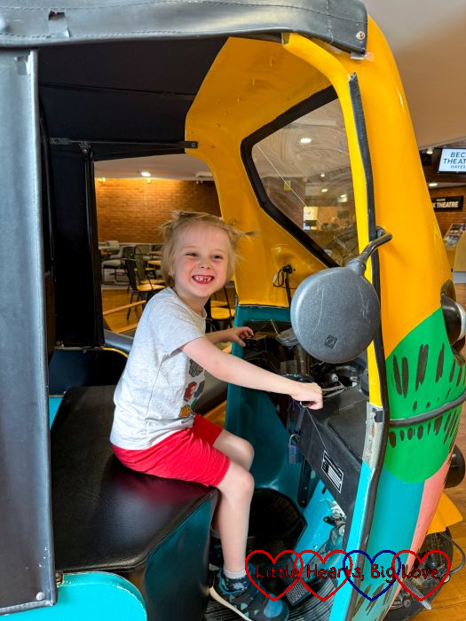 Thomas sitting on a tuk-tuk in the foyer of the Beck Theatre