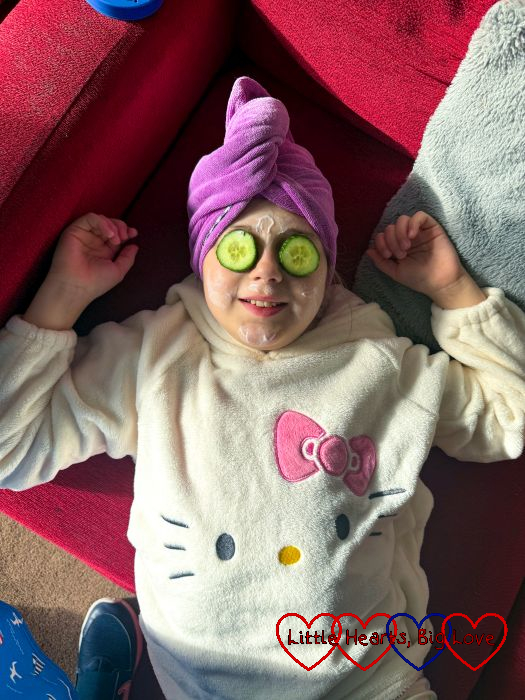Sophie with a hair wrap, face cream and cucumber slices on her eyes