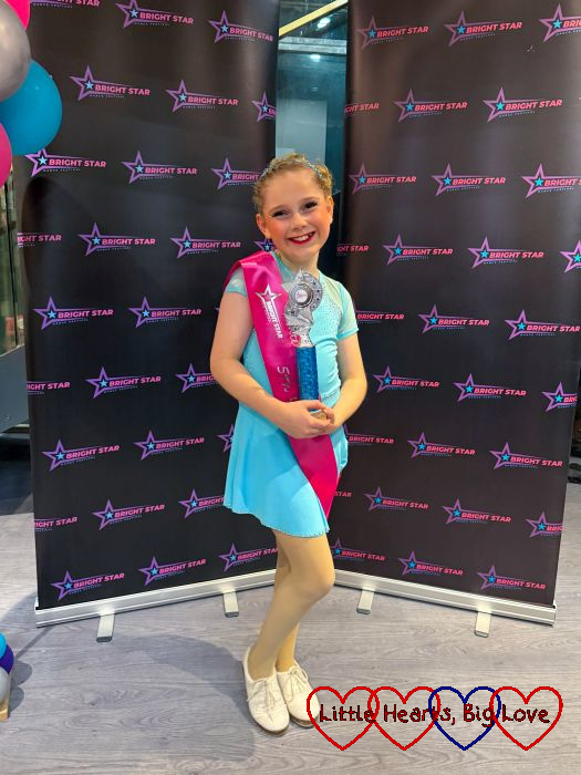 Sophie wearing her Miss Bright Star sash and holding her trophy