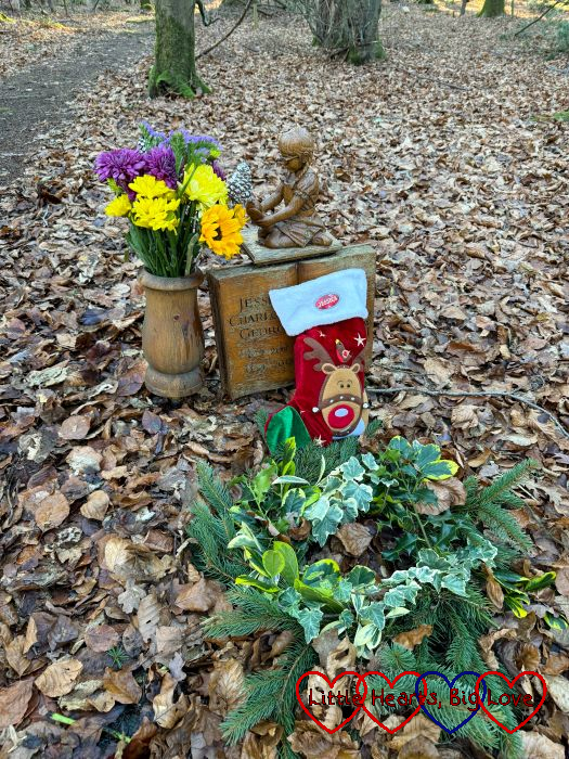 A Christmas wreath, stocking and flowers at Jessica's forever bed