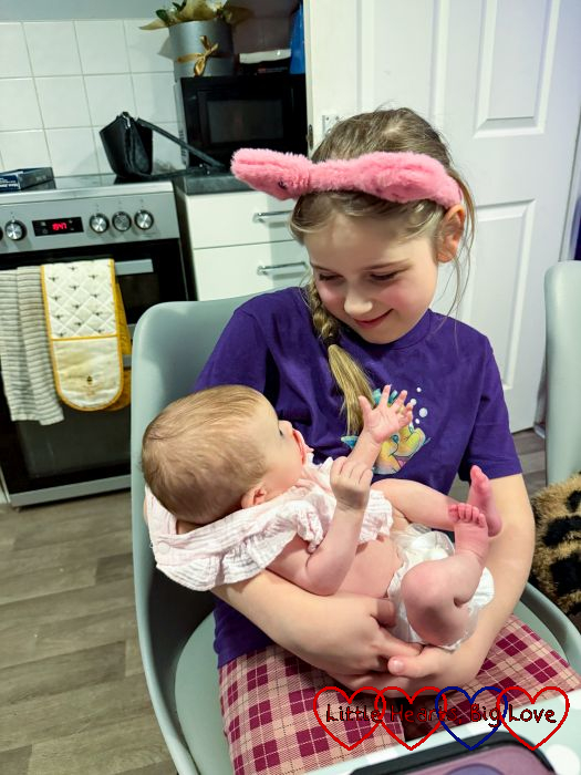 Sophie cuddling her baby cousin
