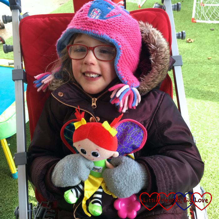 Jessica sitting in her buggy holding her Kerry doll