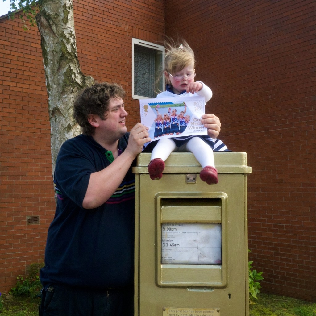 Jessica sitting on a gold postbox in Oxford with Daddy standing next to her