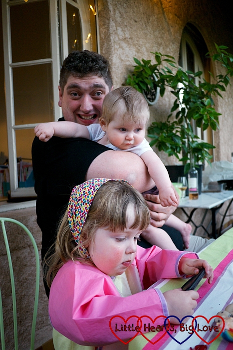 Hubby holding baby Sophie with Jessica sitting at a table in front of them