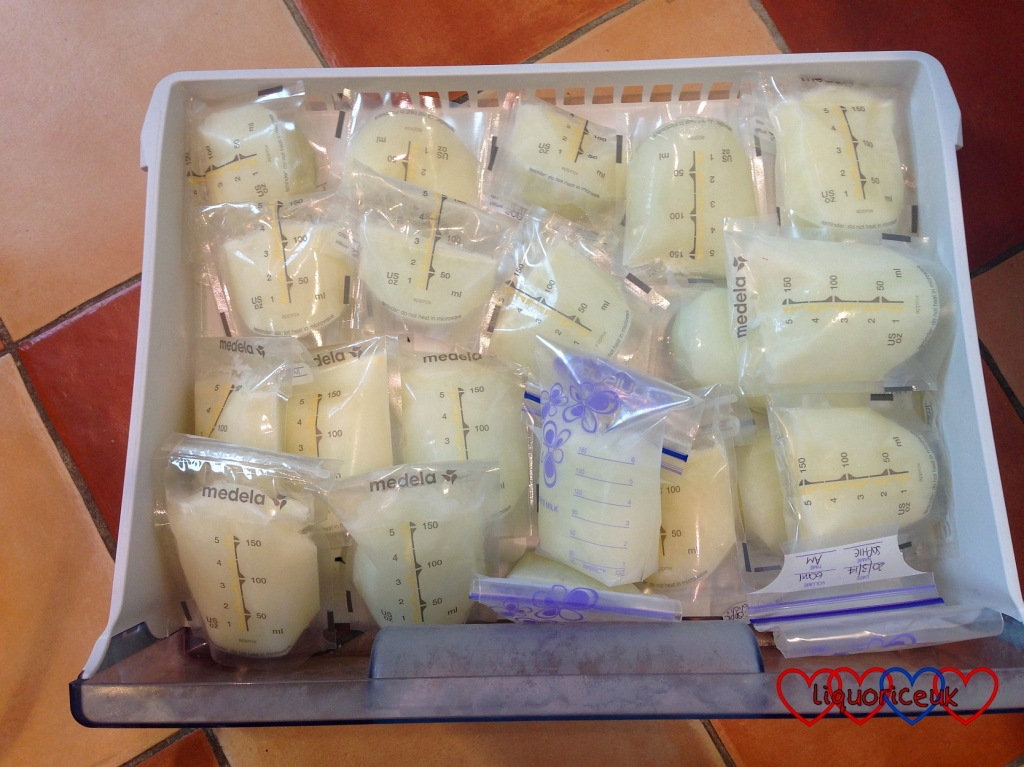 A freezer drawer full of pouches of frozen expressed breastmilk