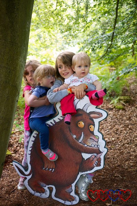 Jessica and Sophie with their cousins standing by a cut-out Gruffalo on the Gruffalo trail at Alice Holt Forest