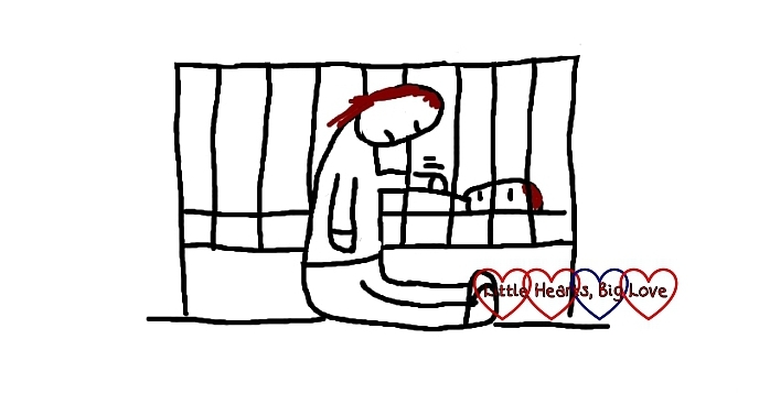 A cartoon of a mum dozing off while sitting on the floor patting her baby through the bars of his/her cot