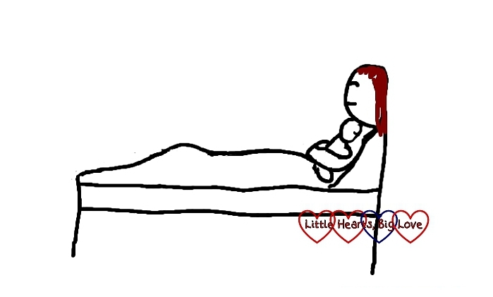 A cartoon of a mum dozing while sitting up in bed cuddling her baby