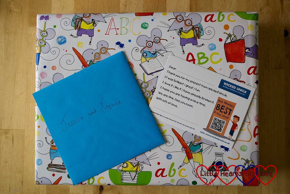 A gift wrapped parcel with a card and a thank you note