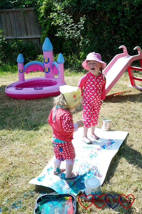 Jessica and Sophie doing footprint painting in the garden