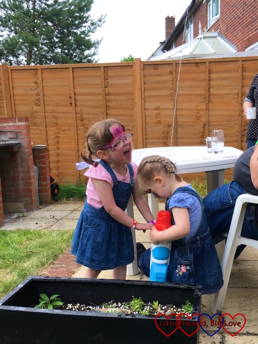 Jessica and Sophie having a water fight in our friends' garden