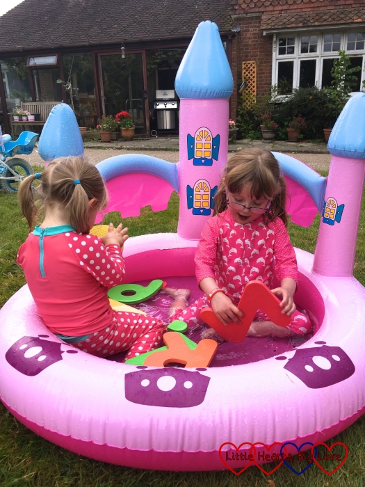 Jessica and Sophie splashing in the paddling pool in Grandma and Grandad's garden
