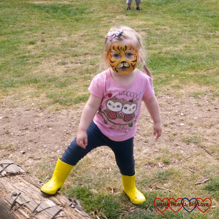 Sophie with her face painted like a tiger in the park