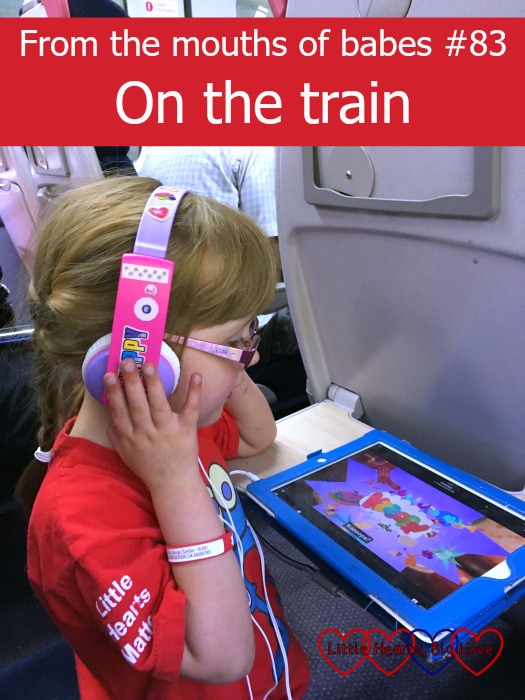 Jessica listening to CBeebies on her "earmuffles" on the train with the text "From the mouths of babes #83 - On the train"