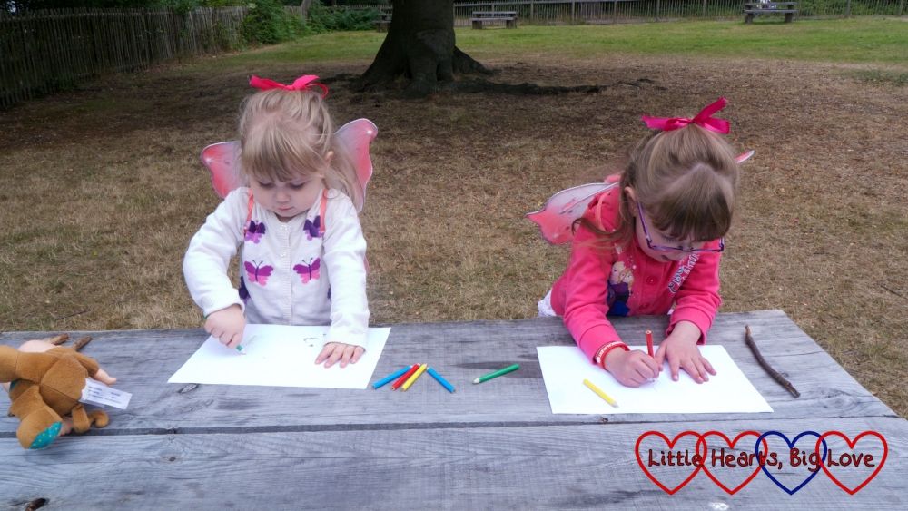 Jessica and Sophie drawing some pictures of fairies in the woods