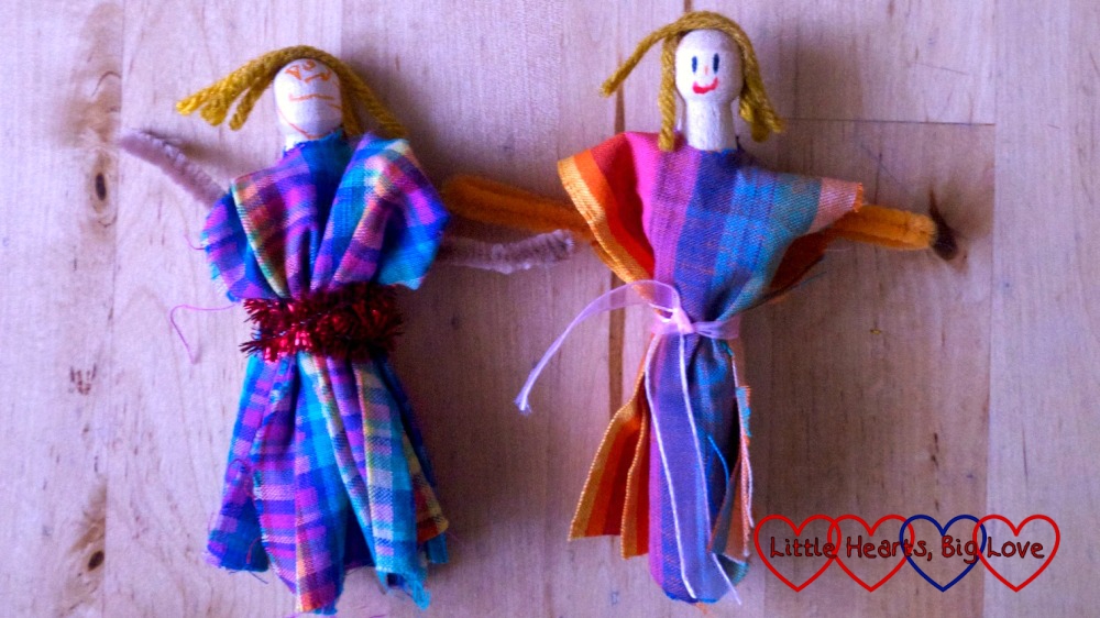 Two dolls made from wooden clothes pegs, scraps of fabric and pieces of wool