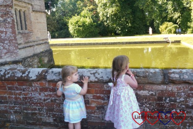 Jessica and Sophie looking across the moat at Baddesley Clinton