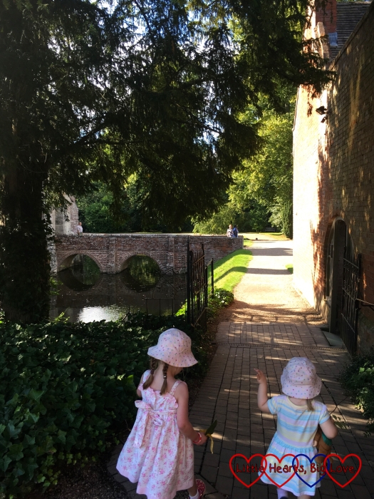 Jessica and Sophie walking towards the bridge and the house at Baddesley Clinton