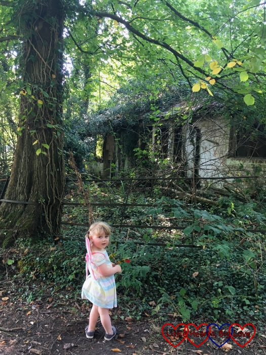 Sophie standing outside a disused house in the woods
