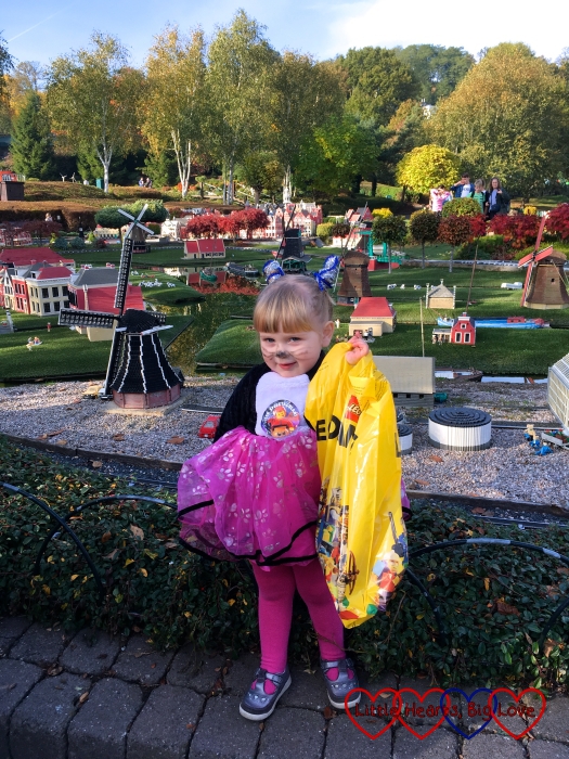 Sophie at Miniland wearing her cat costume and holding the bag containing her prize for winning the fancy dress competition