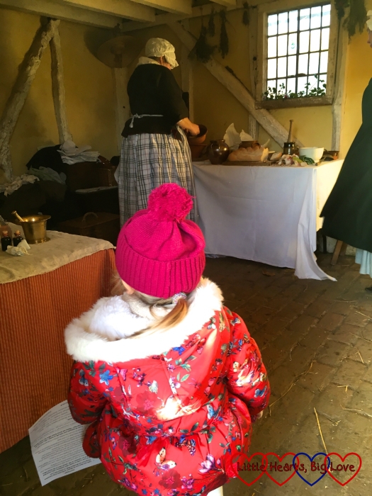 Sophie watching the women preparing a meal in Leagrove Cottage