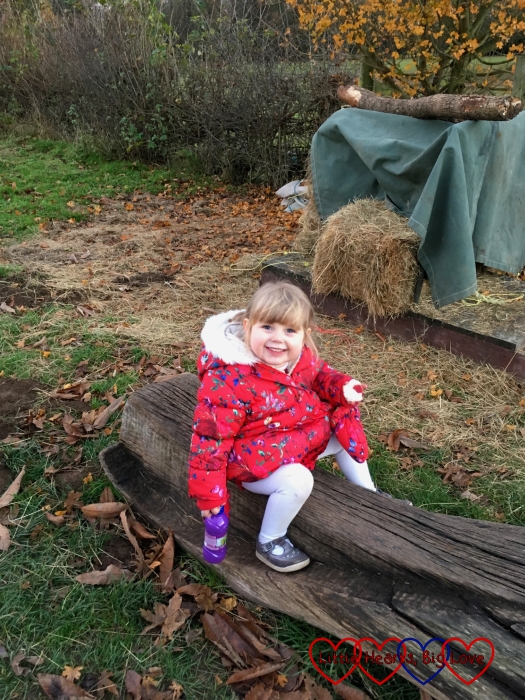 Sophie sitting on a bench with a big smile on her face