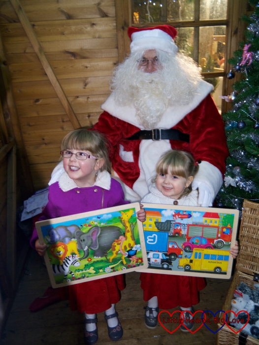 Jessica and Sophie with their wooden jigsaw puzzles posing for a photo with Father Christmas