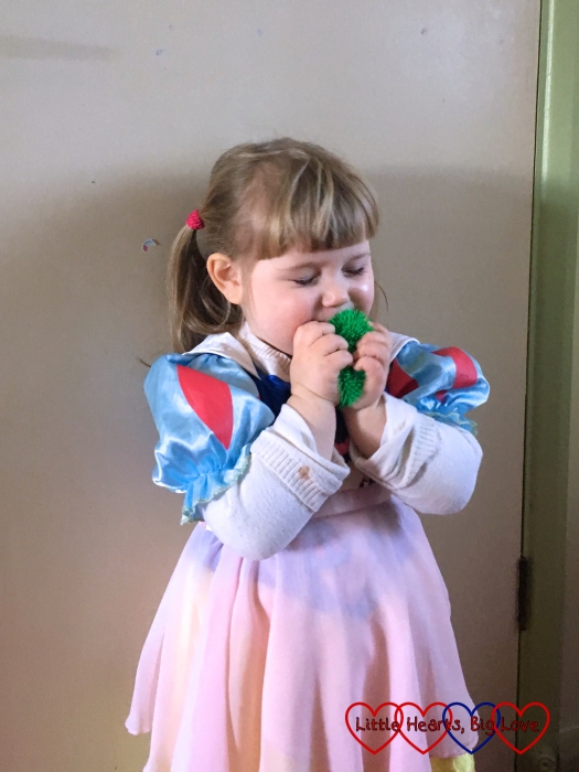 Sophie wearing her princess dress and kissing her toy frog