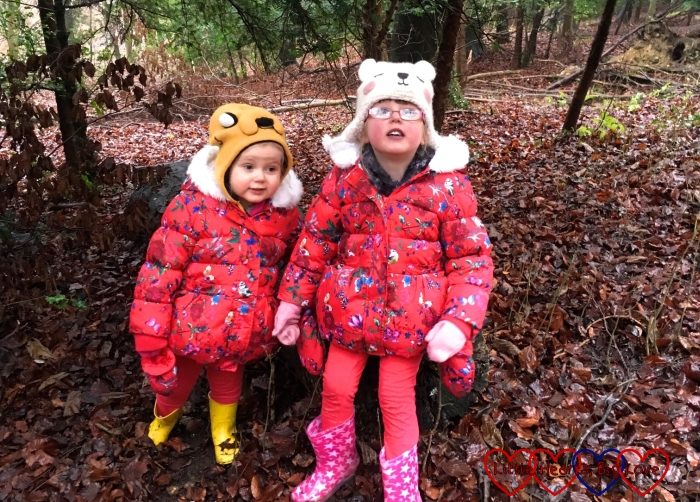 Jessica and Sophie sitting together on a log in the woods