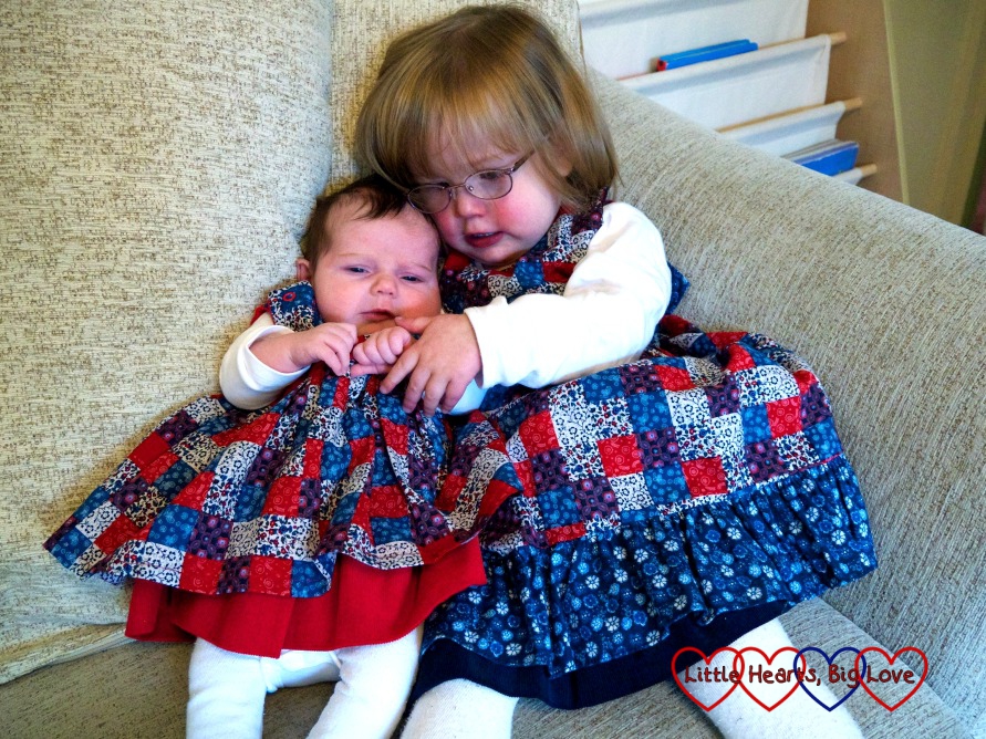 Baby Sophie and a 2-year old Jessica in co-ordinating patchwork print reversible dresses from Seesaw Children's Clothes