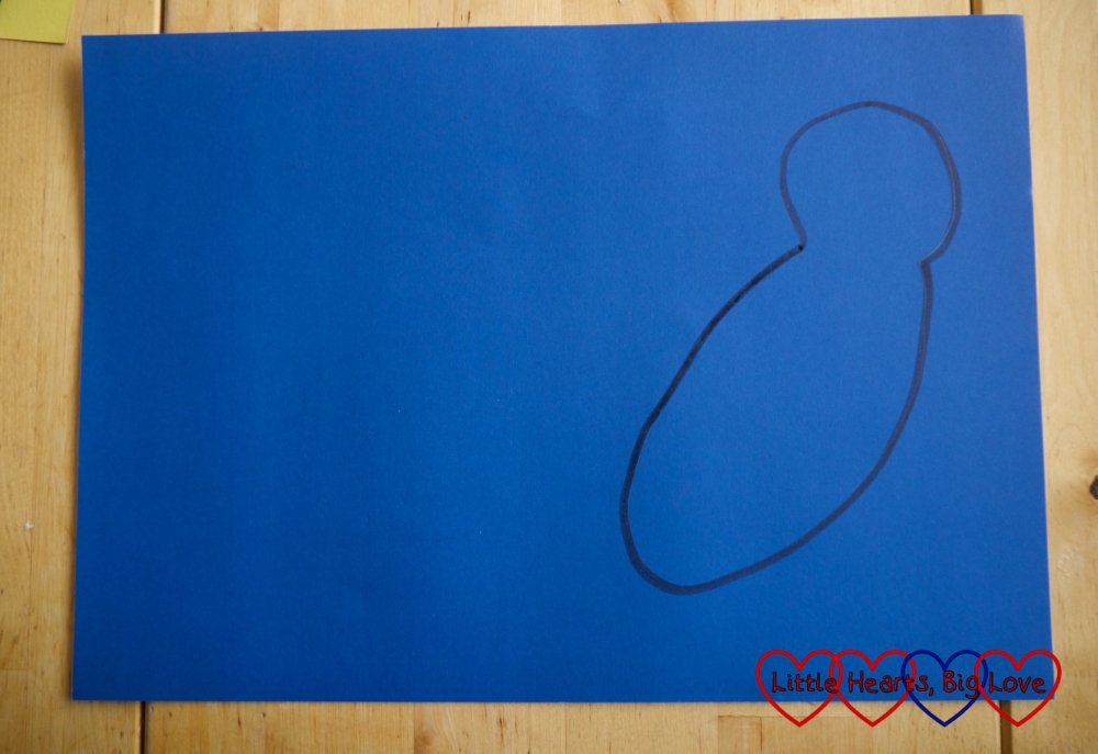 A parrot outline drawn on a piece of coloured cardboard