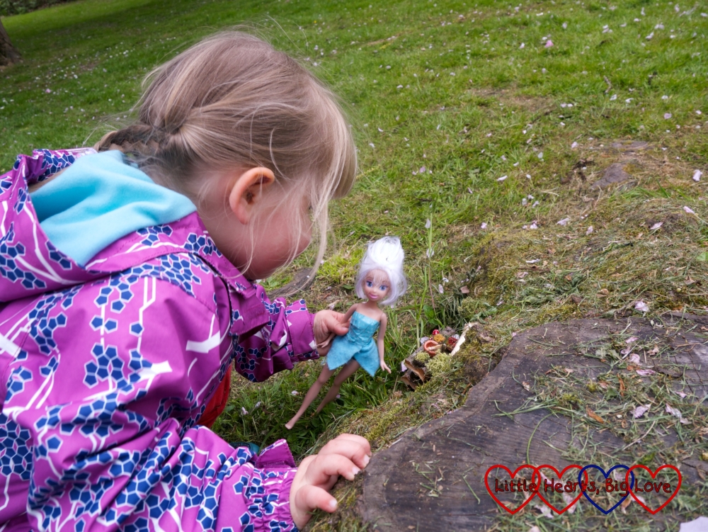 Sophie with her Periwinkle fairy doll looking at the fairy doors