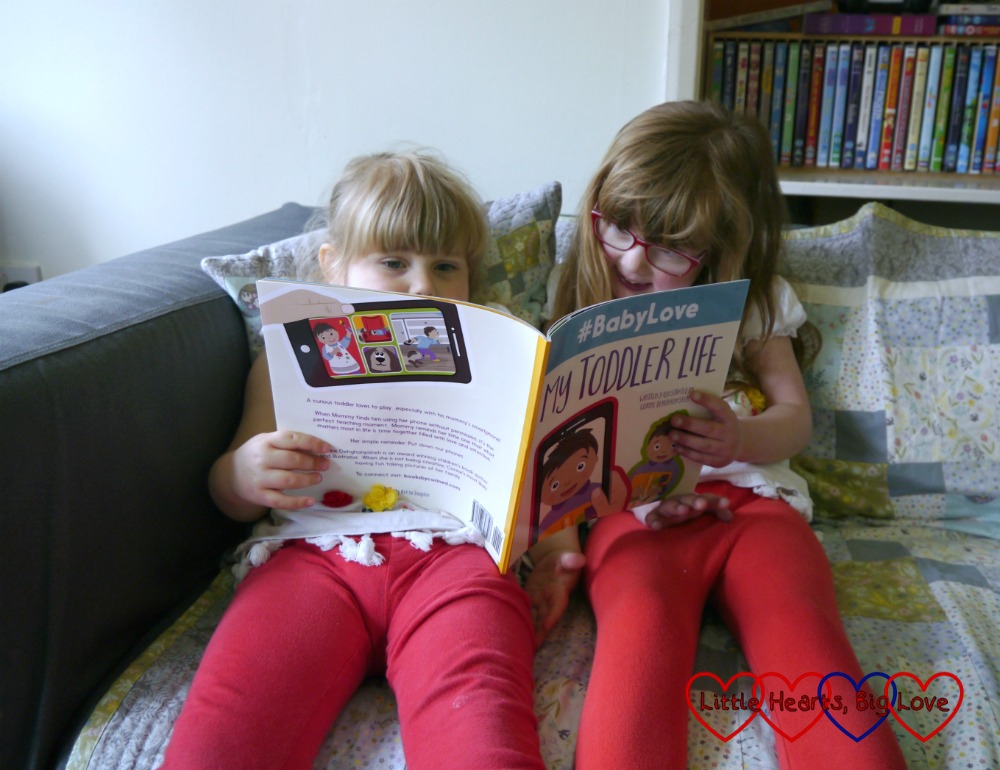 Jessica and Sophie sitting on the sofa reading #BabyLove: My Toddler Life