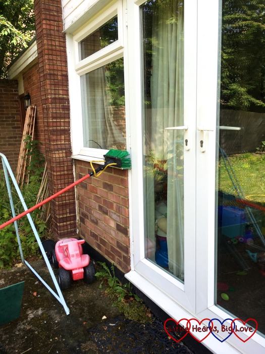 Cleaning the windows outside with a brush on a pole