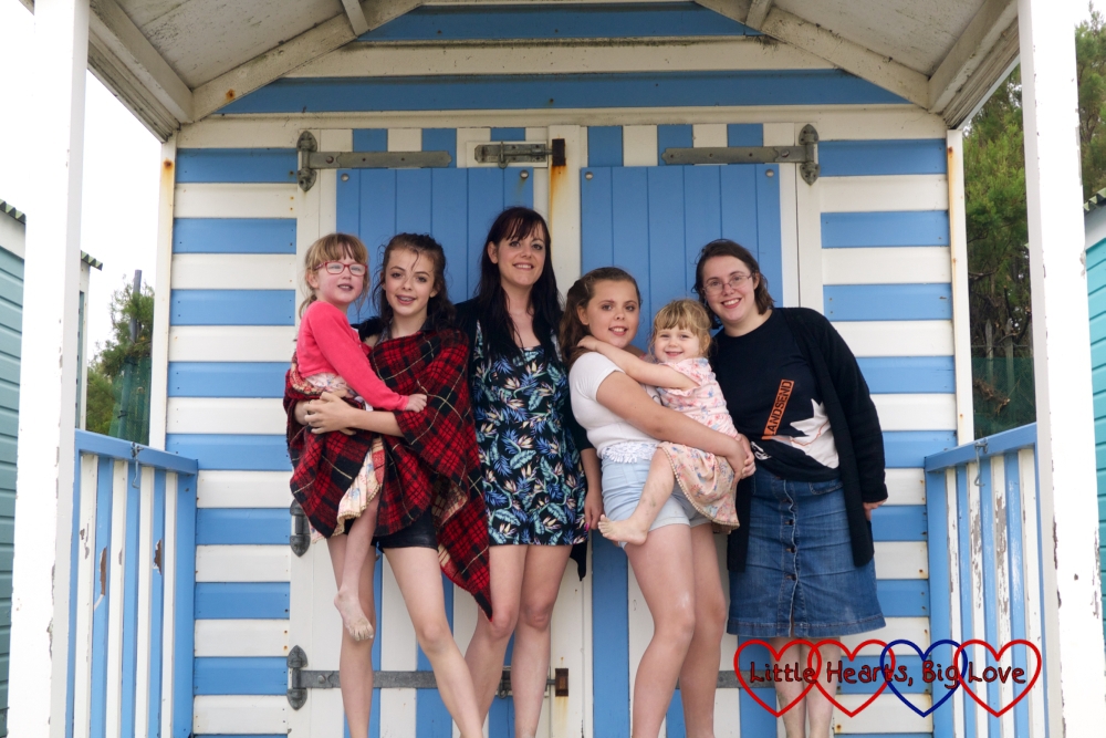 Jessica, cousin Ebony, Auntie Fizz, cousin Erin, Sophie and me standing outside a blue and white beach hut on West Wittering beach