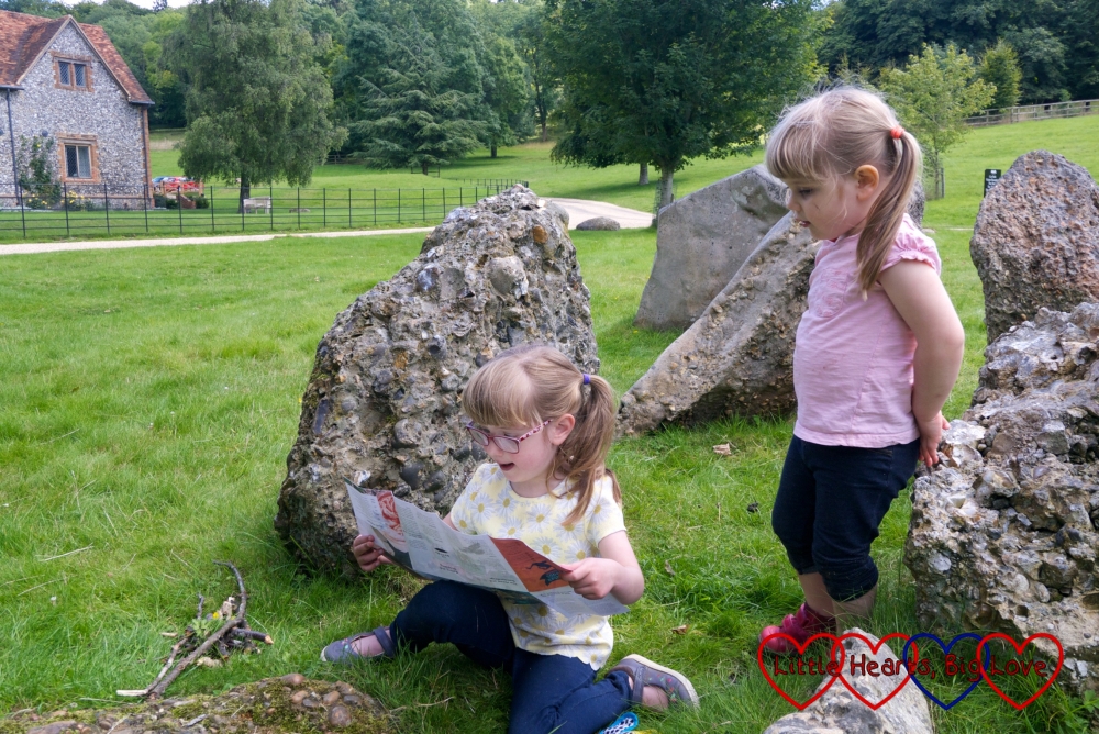 Jessica sitting in the stone circle at Stonor Park and looking at her map with Sophie standing behind her