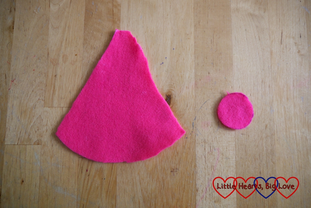 A cone and circle cut out of pink felt