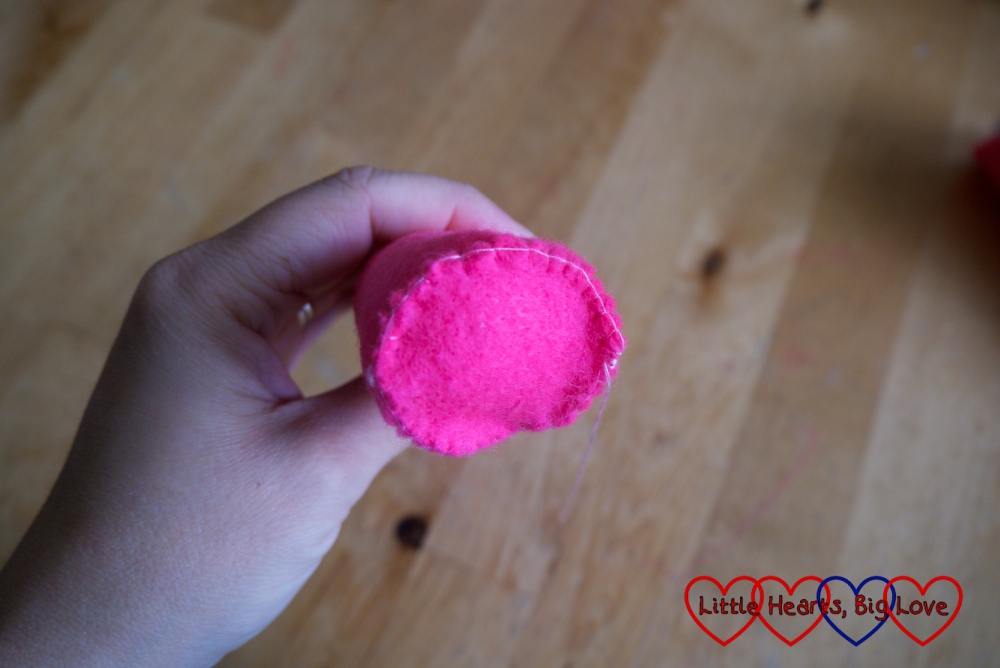 A circle of pink felt stitched to the base of a stuffed pink felt cone
