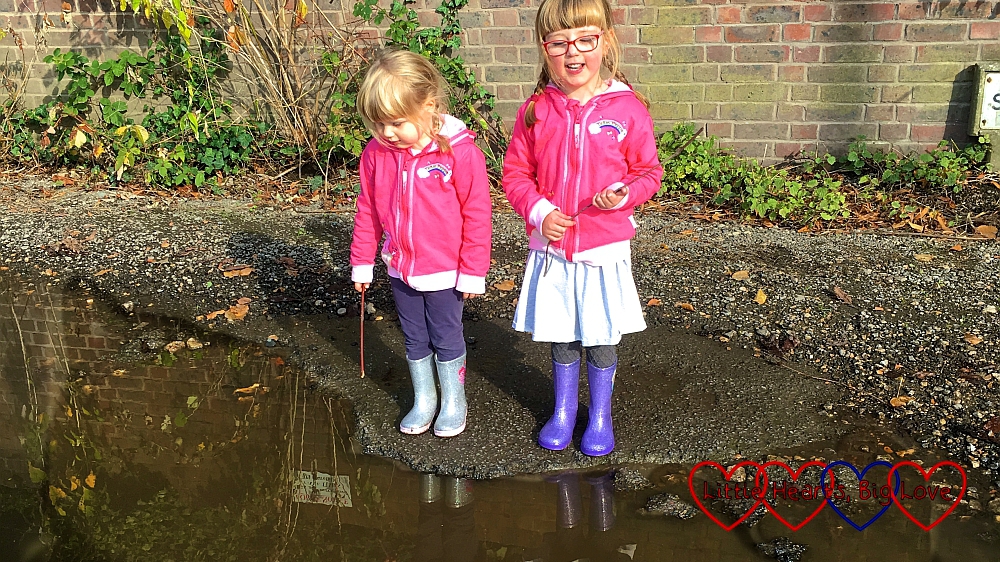 Jessica and Sophie looking into their reflections in a puddle