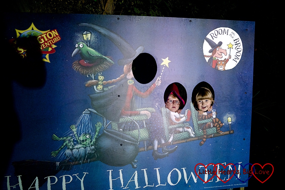 Jessica and Sophie peeping through the holes in the Room on the Broom Happy Halloween board
