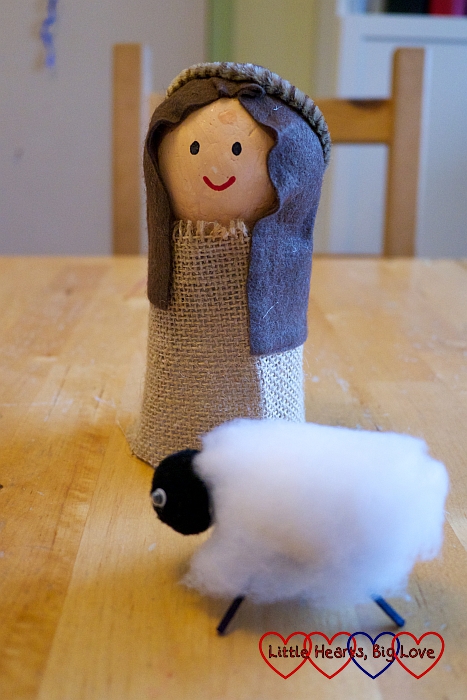 A shepherd figure with a sheep
