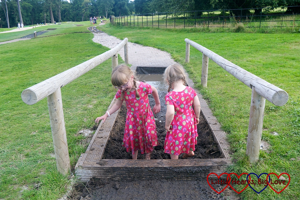 Sophie and Jessica walking through mud on the barefoot walk