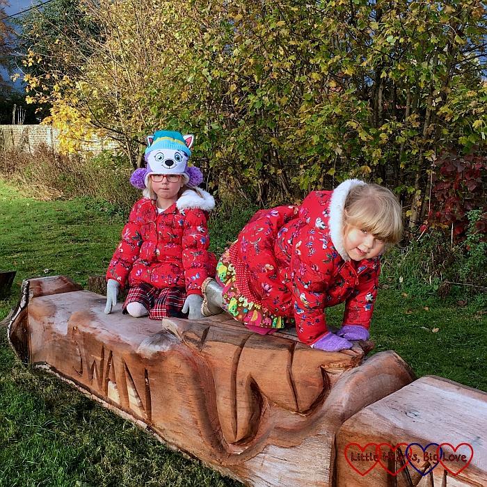 Jessica and Sophie on a carved wooden bench