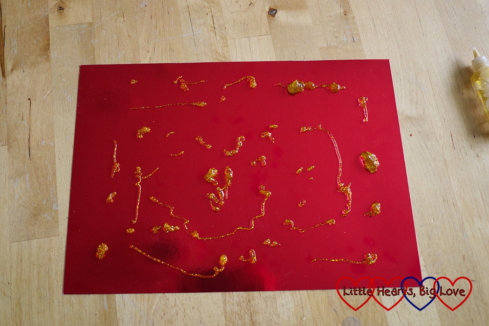The red shiny paper decorated with gold glitter patterns