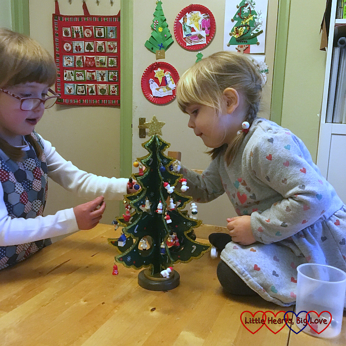 Jessica and Sophie decorating their wooden Christmas tree