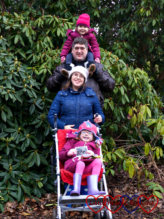 A "totem pole" photo - Sophie on hubby's shoulders, me in front of hubby and Jessica in front of me in the buggy holding the scan photo of "Peanut"