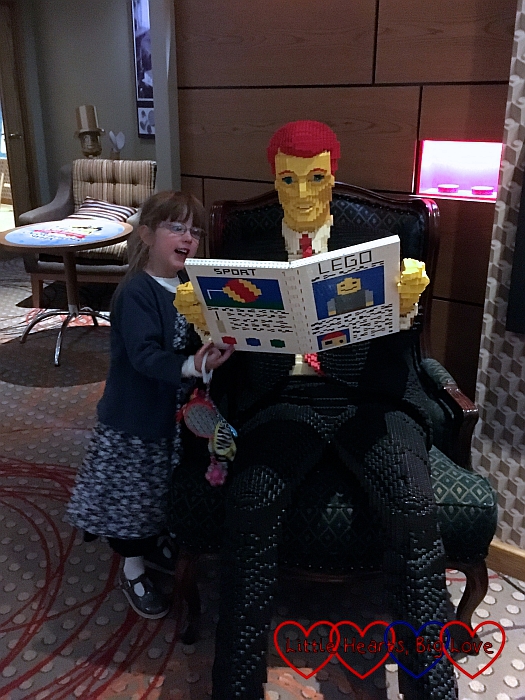 Jessica with the Lego man reading his newspaper in the Lego lounge