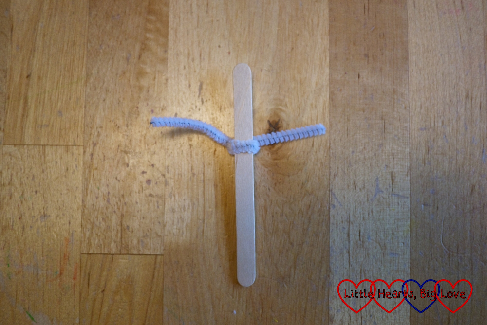 A craft stick with a pipe cleaner wrapped around it