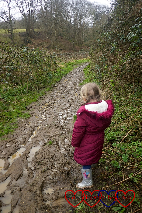 Sophie looking at the muddy footpath leading to the geocache